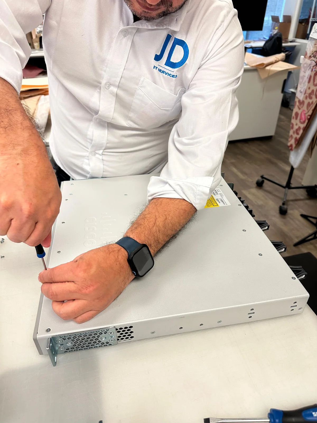 Técnico de JD SPECIALIST realizando mantenimiento a un equipo tecnológico.